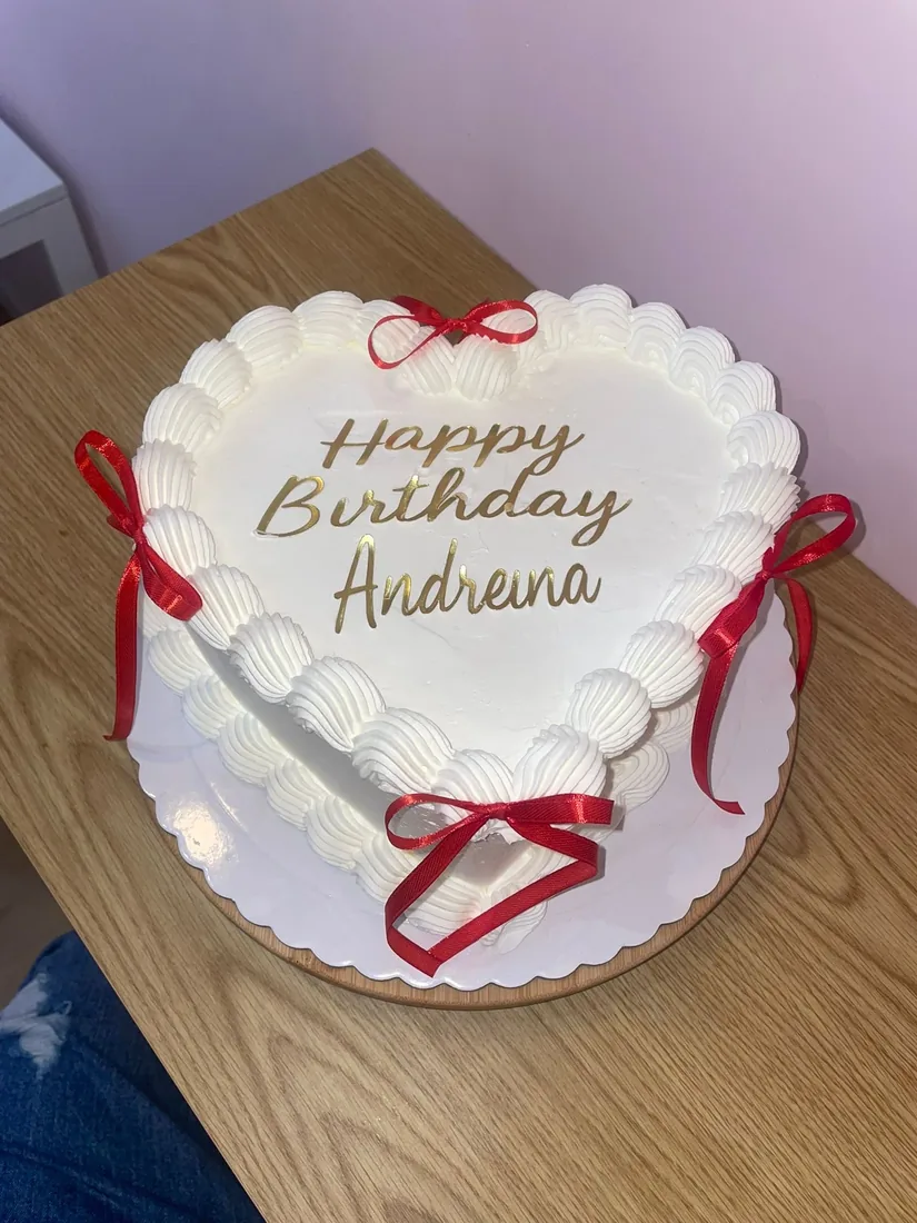 Tarta de cumpleaños blanca con lazos rojos